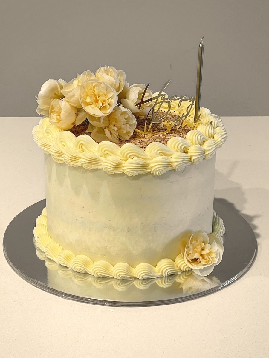 Lemon-yellow cake with piped scallops and dried roses