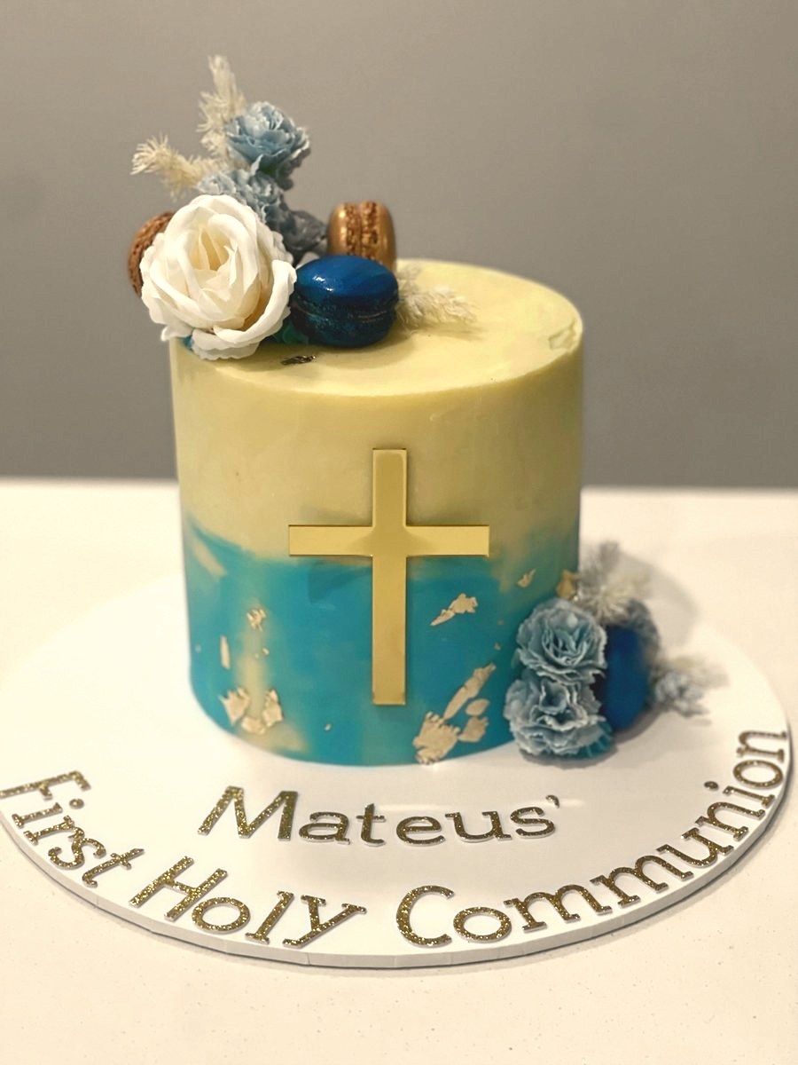 First communion cake with a gold cross and blue flowers