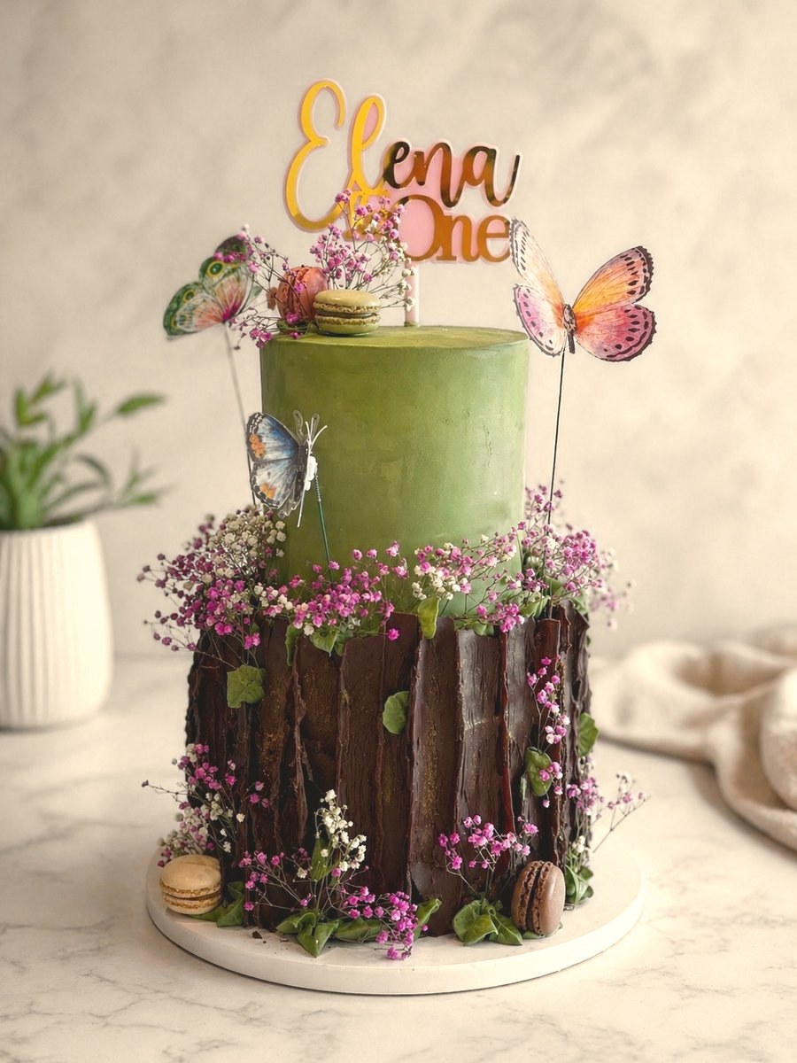 First birthday cake with a green top tier, dried flowers and butterflies
